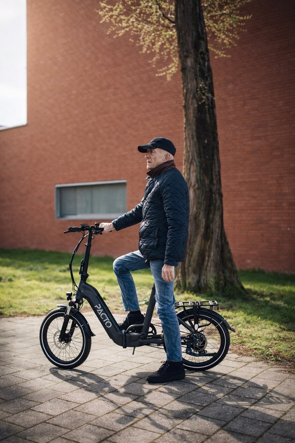 Man op zwart grijs PACTO elektrische  vouwfiets (folding bike) in stad compacte en moderne elektrische vouwfiets