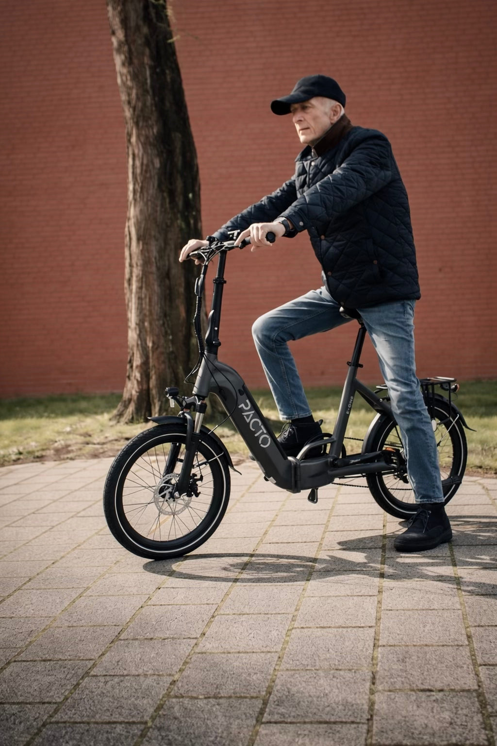 Man op zwart grijs PACTO elektrische  vouwfiets (folding bike) in stad compacte en moderne elektrische vouwfiets
